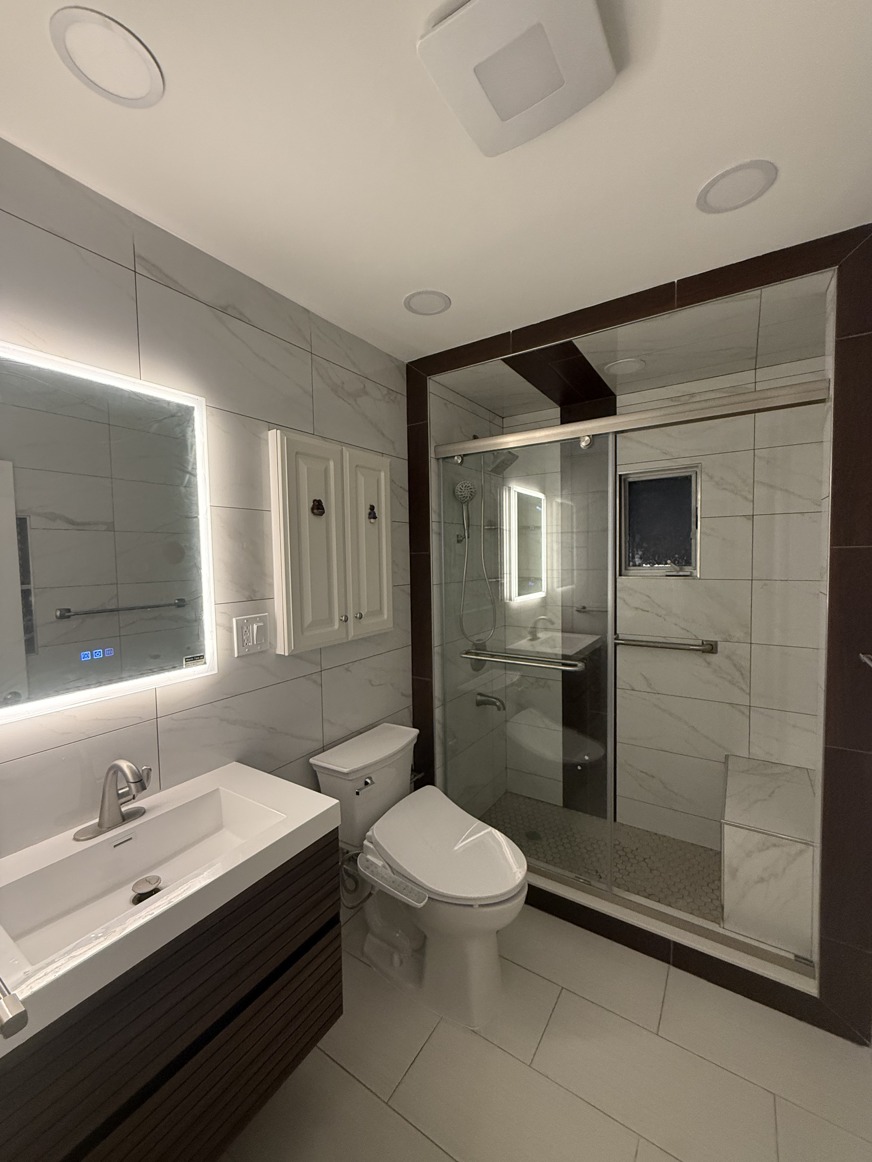 Bathroom remodel with LED mirror and glass shower